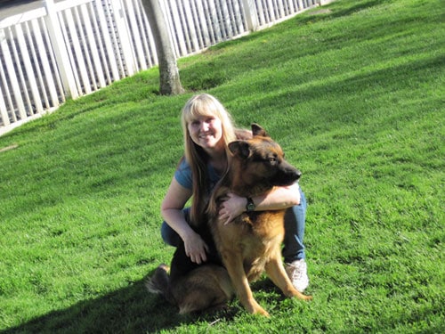 Woman squatting with her personal protection dog