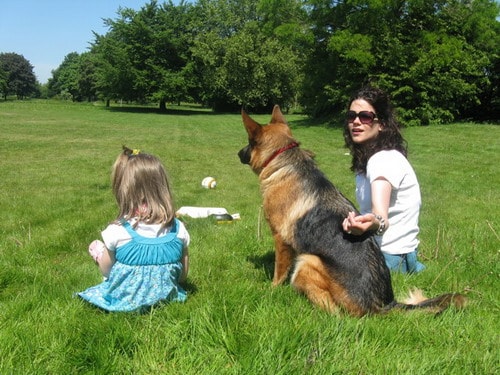 Woman and her little daughter with their personal protection dog