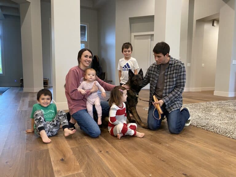 Family happily sitting around their new Protection Dog.